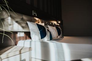 a bedroom with a bed with pillows on it at Business Hotel Plovdiv - Central Location in Plovdiv +93 photos