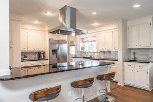 a kitchen with white cabinets and a counter with stools at Sleeps 6-Whispering Pines Lake Front 