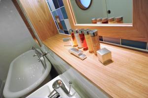 a bathroom with a sink and a counter with bottles of soap at The Brudenell in Aldeburgh +37 photos