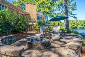 a patio with a fire pit and an umbrella at Sleeps 6-Whispering Pines Lake Front 