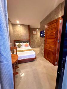 a small bedroom with a bed and a table at RL Harbor Inn in El Nido