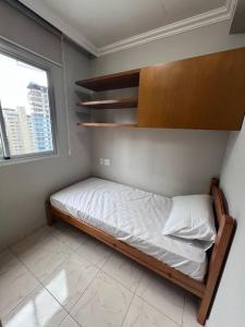 Habitación pequeña con cama y ventana en Apartamento Paulista, en São Paulo