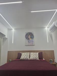 a bedroom with a bed with a painting on the wall at Flat Makia Beach Experience Muro Alto in Porto De Galinhas +19 photos