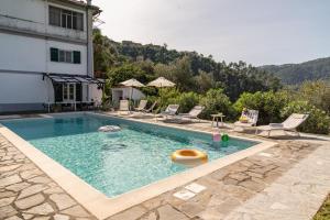 einen Pool mit Stühlen und ein Gebäude in der Unterkunft Near Cinque Terre - Mountain Farmhouse with Pool in Tivegna