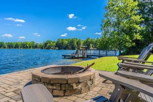 eine Feuerstelle auf einer Terrasse neben einem See in der Unterkunft Sleeps 7- Whispering Pines Lake Front 