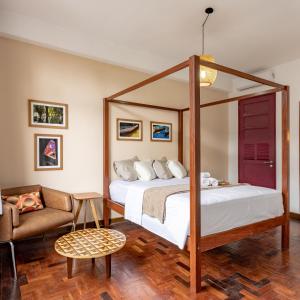 a bedroom with a canopy bed and a couch at Hotel Casa do Bispo in Manaus