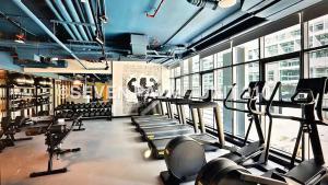 a gym with a bunch of treadmills and machines at Luxus-Studio mit Private Beach in Top-Lage, Meerblick & Infinity Pool! in Dubai
