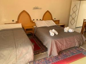 a bedroom with two beds with towels on them at Résidence Mer et soleil in Agadir