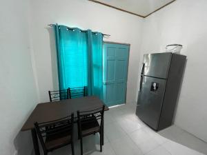 ein Esszimmer mit einem Tisch und einem Kühlschrank in der Unterkunft Tourquesa Excellent WiFi Private in Liberia
