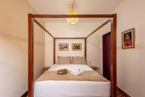 sypialnia z łóżkiem z drewnianą ramą w obiekcie Hotel Casa do Bispo w mieście Manaus