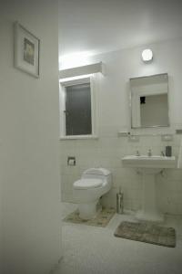 a white bathroom with a toilet and a sink at Apartamento completo centro de Bogotá in Bogotá