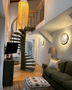 a living room with a couch and a spiral staircase at Bloom Cottage I - Sintra montain in Sintra