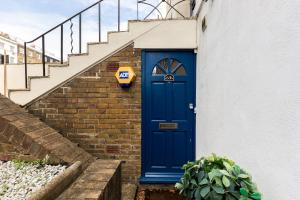 une porte bleue sur le côté d'un immeuble avec des escaliers dans l'établissement The Clapham Villas, à Londres