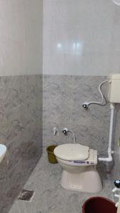 a bathroom with a toilet and a sink at Ghanshyam hotel in Dwarka