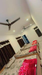 a bedroom with two beds and a ceiling fan at Ghanshyam hotel in Dwarka