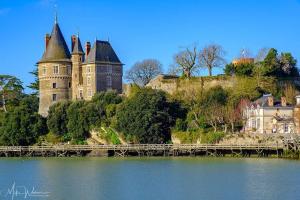 a castle on a hill with a bridge over the water at Charmante maison à 100M de la plage in Pornic