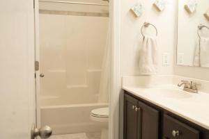 a bathroom with a toilet and a sink and a shower at Sleeps 9- In Whispering Pines in Carthage