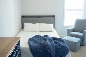 1 dormitorio con 1 cama con manta azul y silla en Sleeps 9- In Whispering Pines, en Carthage
