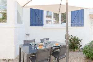 a table and chairs under a white umbrella at Charmante maison à 100M de la plage in Pornic +15 photos