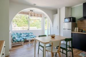 a kitchen and living room with a table and a couch at Charmante maison à 100M de la plage in Pornic