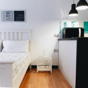 a small bedroom with a white bed and a tv at Casa Silvia in Genova