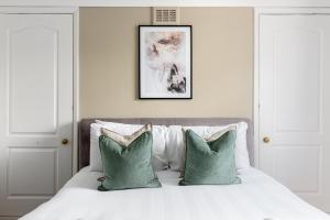 - une chambre avec un lit doté d'oreillers verts et blancs dans l'établissement The Clapham Villas, à Londres