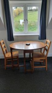 a table and two chairs and a window at Farm Loft in Shepton Mallet