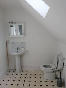 a bathroom with a toilet and a sink at Farm Loft in Shepton Mallet