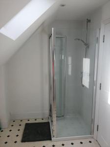 a bathroom with a shower with a glass door at Farm Loft in Shepton Mallet