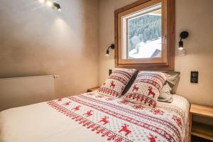 een slaapkamer met een bed en een raam bij Alpen Chalet in Morzine