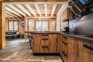 cocina grande con armarios de madera y mesa en Alpen Chalet en Morzine