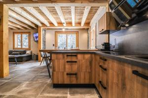 een grote keuken met houten kasten en een tafel bij Alpen Chalet in Morzine