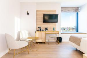 a bedroom with a bed and a desk and a tv at Hotel Málaga Vibes in Málaga