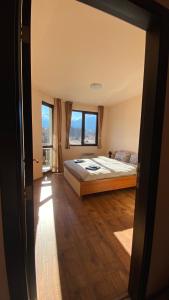 um quarto com uma cama e uma grande janela em Snow Lodge Mountain view em Bansko