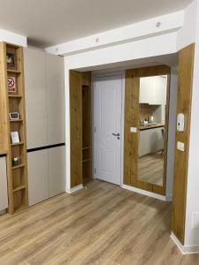 una camera con pareti bianche, porta e pavimenti in legno di Central luxury apartment Iasi a Iaşi