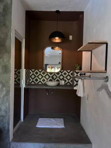 uma casa de banho com um lavatório e um espelho em Depto Sayula HoMe con alberca 6 em Sayulita