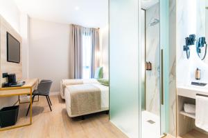 a hotel room with a bed and a desk at Hotel Málaga Vibes in Málaga