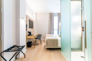 a hotel room with a bed and a desk and a bedroom at Hotel Málaga Vibes in Málaga