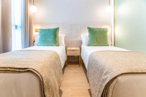 two beds sitting next to each other in a room at Hotel Málaga Vibes in Málaga