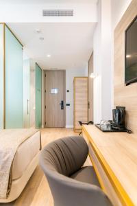a bedroom with a bed and a desk with a chair at Hotel Málaga Vibes in Málaga