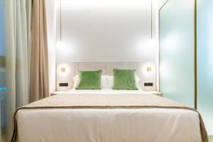 a bedroom with a large bed with two green pillows at Hotel Málaga Vibes in Málaga