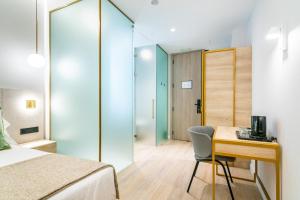 a bedroom with a desk and a bed and a table and chair at Hotel Málaga Vibes in Málaga
