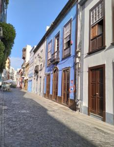 una strada di ciottoli con edifici blu e bianchi di Ático Los Balcones a Santa Cruz de la Palma