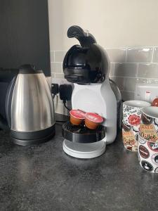 a coffee maker sitting on a counter with two cupcakes at Castletroy Apartment in Limerick
