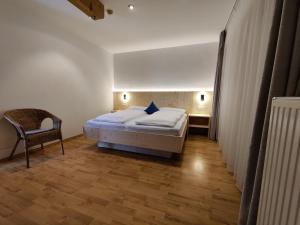 sypialnia z łóżkiem i krzesłem w obiekcie Residence Klementhof 1 w mieście Fiumes
