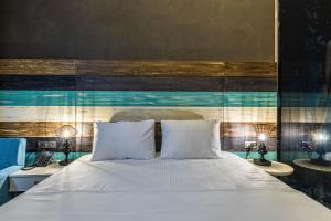 a bedroom with a bed with white sheets and two lamps at Gözegir Hotel in Bodrum City