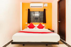 1 dormitorio con 1 cama grande con almohadas rojas en Shri Ganpati Palace, en Chinhat