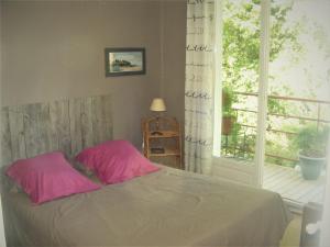 - une chambre avec un lit avec des draps roses et une fenêtre dans l'établissement Hulotte, à Soorts-Hossegor