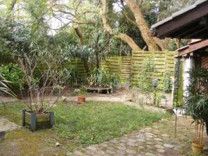 un jardin avec une clôture en bois et un banc dans l'établissement Hulotte, à Soorts-Hossegor