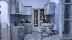 una cocina con armarios blancos y azulejos azules en Luxury apartment in the city center en Tírnavos